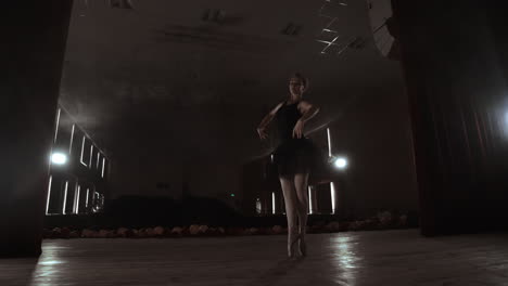 SLOW-MOTION.-unrecognizable-beautiful-ballerina-performing-on-dark-smoke-stage.-Blonde-woman-with-hair-in-black.-Ballet-dress-dancing-with-hands