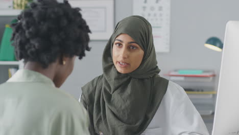Female-Doctor-Or-Consultant-Wearing-Headscarf-Having-Meeting-With-Female-Patient