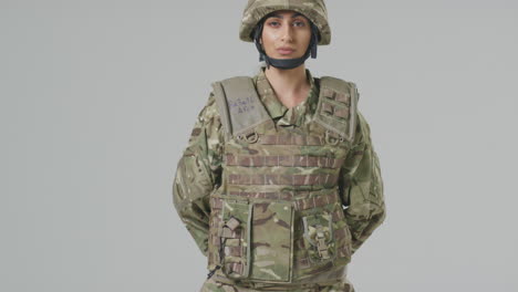 Retrato-De-Estudio-Completo-De-Una-Joven-Soldado-Seria-Con-Uniforme-Militar-Sobre-Fondo-Liso