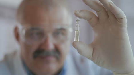 A-pharmacist-holds-a-medicine-in-ampoules-made-of-glass.-A-new-drug-to-fight-viruses-and-diseases.-Medicine-for-coronavirus.-High-quality-4k-footage