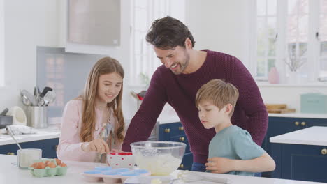 Vater-Mit-Zwei-Kindern-In-Der-Heimischen-Küche-Und-Hat-Spaß-Daran,-Gemeinsam-Kuchen-Zu-Backen