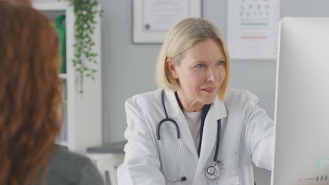 Mature-Female-Doctor-Or-Consultant-Wearing-White-Coat-Having-Meeting-With-Female-Patient