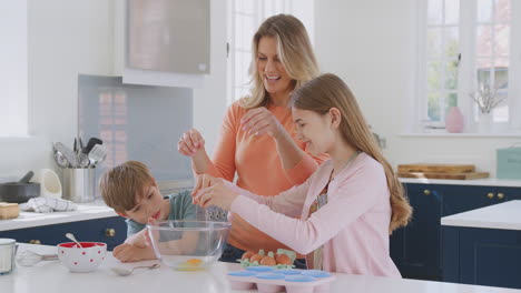 Mother-With-Two-Children-In-Kitchen-At-Home-Having-Fun-Baking-Cakes-Together