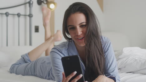 Mujer-Con-Teléfono-Móvil-En-Pijama-Teniendo-Video-Chat-Acostada-En-La-Cama