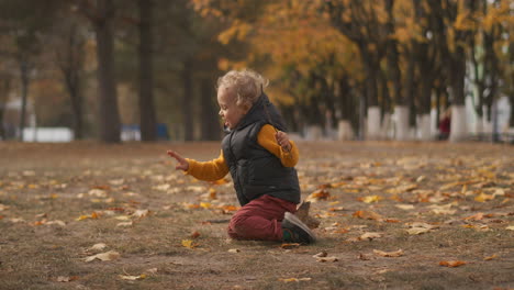 happy-child-is-playing-in-nature-in-park-at-autumn-day-toddler-is-sitting-on-ground-walking-at-weekend-happy-childhood-baby-is-having-fun
