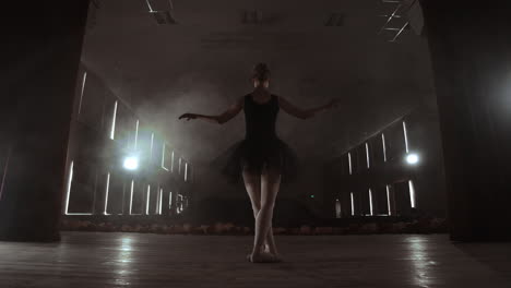 Slow-motion:-prima-ballet-on-stage-rehearsing-performance-in-the-dark-light-of-the-contra.-The-lights-from-the-hall