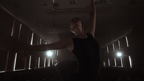 Elegant-ballet-dancer-in-black-tutu-in-studio-with-smoke.-And-backlit