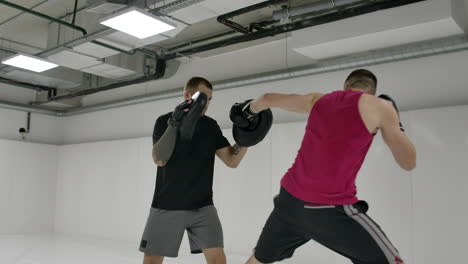 Kick-boxer-inflicts-attacking-blows-with-his-hands-and-feet-dodging-the-blows-of-the-opponent.-Training-of-shock-equipment