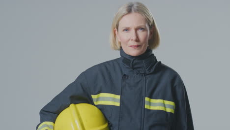 Studioporträt-Einer-Ernsthaften,-Reifen-Feuerwehrfrau-Vor-Einfachem-Hintergrund