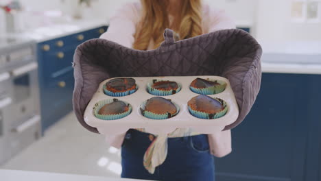 Portrait-Of-Teenage-Girl-Taking-Out-Tray-Of-Burnt-Homemade-Cupcakes-From-The-Oven-At-Home