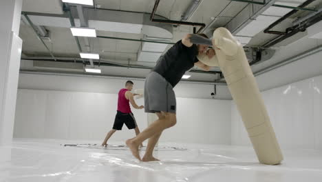 Two-Male-wrestlers-perform-a-dummy-throw-on-mats-in-slow-motion.-Professional-grappling-fighters