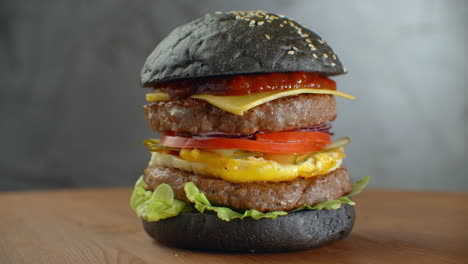 Schwarzer-Burger-Mit-Grünem-Gemüse.-Schwarzer-Burger-Auf-Holztisch