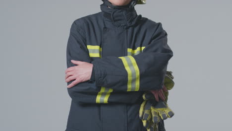 Studioporträt-In-Voller-Länge-Einer-Lächelnden-Reifen-Feuerwehrfrau-Mit-Helm-Auf-Schlichtem-Hintergrund
