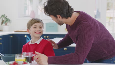 Father-Having-Breakfast-With-Son-Wearing-School-Uniform-At-Home-In-Kitchen