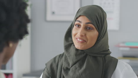 Close-Up-Of-Female-Doctor-Or-Consultant-Wearing-Headscarf-Having-Meeting-With-Female-Patient