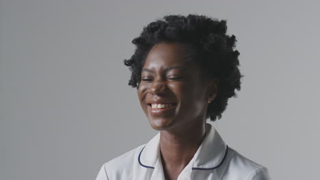 Studioporträt-Einer-Lachenden-Krankenschwester-In-Uniform-Vor-Schlichtem-Hintergrund