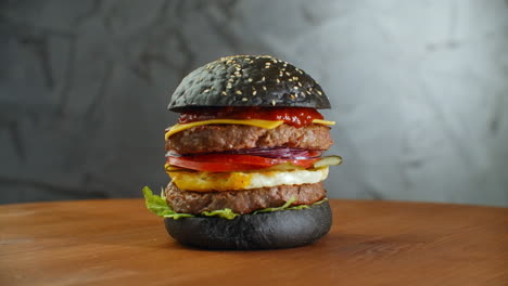 Burger-Oder-Hamburger-Mit-Schwarzbrot-Auf-Einem-Unscharfen-Hintergrund-Aus-Blättern