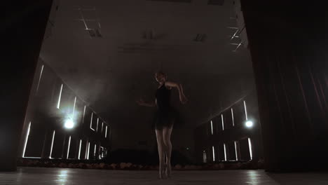 Slow-motion:-the-prima-ballerina-in-a-black-dress-performs-rotations-and-graceful-dance-moves.-The-camera-moves-on-gimbal