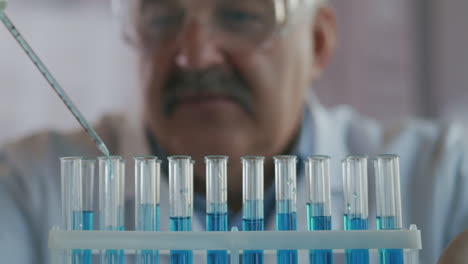 Scientist-drop-liquid-in-a-test-tube-and-shaking-in-laboratory.-Pipette-Dripping-a-Colored-Chemical-Substance-in-a-Test-Tubes.-Close-up-of-Science-Man-Working.-High-quality-4k-footage