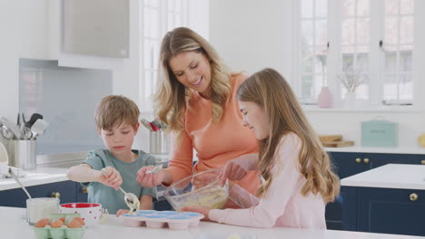 Mutter-Mit-Zwei-Kindern-In-Der-Heimischen-Küche-Und-Hat-Spaß-Daran,-Gemeinsam-Kuchen-Zu-Backen