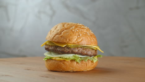A-delicious-cheeseburger-served-on-a-wooden-platter.