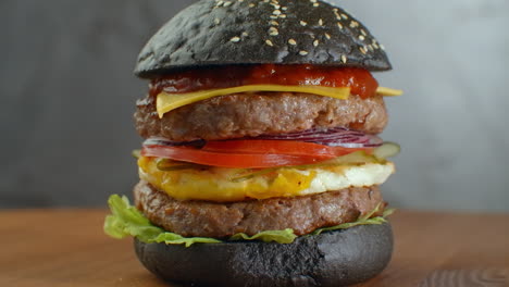 Burger-Oder-Hamburger-Mit-Schwarzbrot-Auf-Einem-Unscharfen-Hintergrund-Aus-Blättern