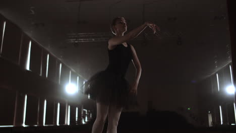 Elegant-ballet-dancer-in-black-tutu-in-studio-with-smoke.-And-backlit