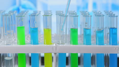 Laborassistent-Gibt-Grüne-Flüssigkeit-In-Reagenzglas-Und-überwacht-Chemische-Reaktion.-Techniker-Tropft-Die-Lösung-Vorsichtig-Aus-Der-Pipette-In-Glasröhrchen-Zur-DNA-Analyse.-Pharmazeutisches-Labor.-Hochwertiges-4K-Filmmaterial