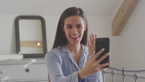 Excited-Woman-With-Mobile-Phone-Wearing-Pyjamas-Showing-Engagement-Ring-Video-Chat