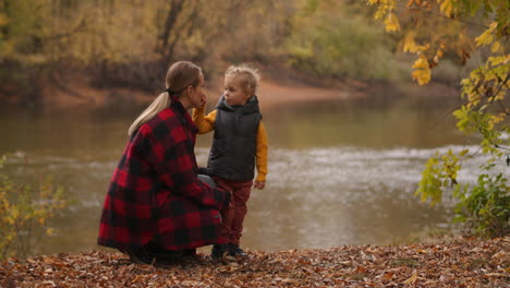 caucasian-family-of-young-mother-and-little-son-are-enjoying-nature-at-forest-at-fall-day-picturesque-landscape-with-calm-lake