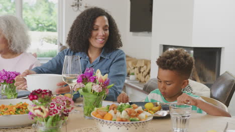 Mother-And-Son-Enjoying-Multi-Generation-Family-Meal-At-Home