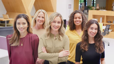 Portrait-Of-Smiling-Multi-Cultural-Female-Business-Team-Standing-In-Modern-Open-Plan-Office