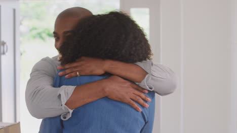 Couple-Hugging-In-Hallway-Of-New-Home-On-Moving-Day