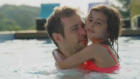 Father-And-Daughter-Having-Fun-In-Swimming-Pool-On-Summer-Vacation-Together