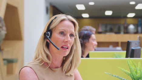 Reife-Geschäftsfrau-Trägt-Telefon-Headset-Und-Spricht-Mit-Anrufer-Im-Kundendienstzentrum
