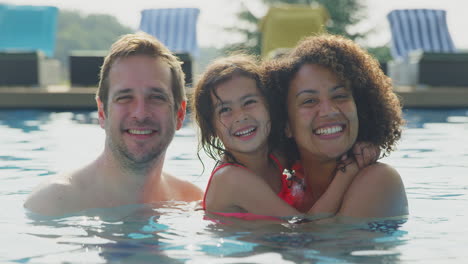 Mother-And-Father-Having-Fun-In-Swimming-Pool-On-Summer-Vacation-With-Daughter