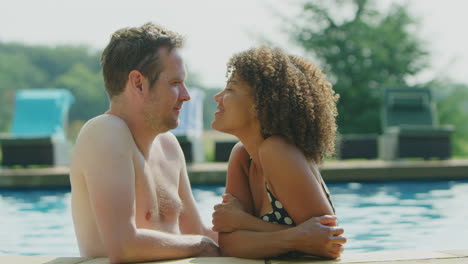 Portrait-Of-Loving-Couple-Relaxing-In-Swimming-Pool-On-Summer-Vacation