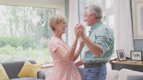 Romantisches-älteres-Rentnerpaar,-Das-Zu-Hause-Gemeinsam-In-Der-Lounge-Tanzt