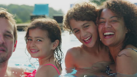 Porträt-Einer-Multiethnischen-Familie,-Die-Sich-Im-Gemeinsamen-Sommerurlaub-Im-Schwimmbad-Entspannt