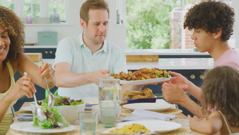 Eine-Multiethnische-Familie-Sitzt-Zu-Hause-Am-Tisch-In-Der-Küche-Und-Isst-Gemeinsam