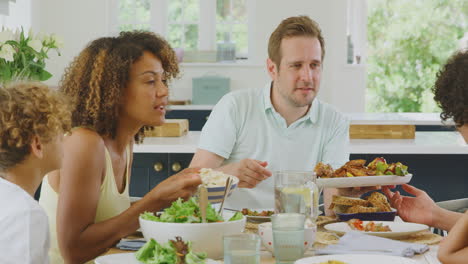 Eine-Multiethnische-Familie-Sitzt-Zu-Hause-Am-Tisch-In-Der-Küche-Und-Isst-Gemeinsam