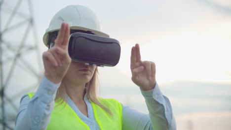 Portrait-of-a-modern-woman-of-the-Comptroller-of-the-engineer-conducting-the-inspection-via-virtual-reality-glasses-and-a-white-helmet-dressed-in-uniform-in-the-background-the-towers-of-power.