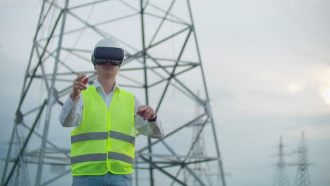 Portrait-of-a-modern-man-of-the-Comptroller-of-the-engineer-conducting-the-inspection-via-virtual-reality-glasses-and-a-white-helmet-dressed-in-uniform-in-the-background-the-towers-of-power.