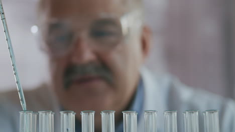 Scientist-drop-liquid-in-a-test-tube-and-shaking-in-laboratory.-Pipette-Dripping-a-Colored-Chemical-Substance-in-a-Test-Tubes.-Close-up-of-Science-Man-Working.-High-quality-4k-footage