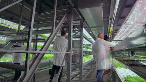 Wissenschaftler-Und-Landwirte-Arbeiten-Im-Team-Zusammen,-Um-Mithilfe-Moderner-Laptops-Und-Tablets-Saubere-Pflanzen-In-Einer-Künstlichen-Umgebung-Zu-Erschaffen.