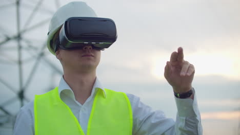 High-voltage-power-lines-controlled-by-a-male-engineer-using-virtual-reality-to-control-power.-Alternative-energy-sources-in-a-modern-city