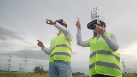 Two-engineers-of-power-engineers-in-VR-glasses-move-their-hands-simulating-the-operation-of-the-interface-of-the-control-system-and-planning-of-high-voltage-lines-for-the-delivery-of-electricity-from-alternative-energy-sources.
