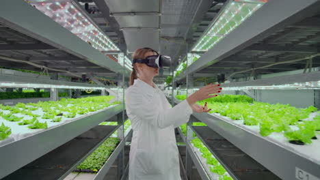 Moderne-Mikrobiologin-Nutzt-Virtual-Reality-Brillen,-Um-Das-Klima-Auf-Einem-Modernen-Bauernhof-Zu-Kontrollieren-Und-Zu-Kontrollieren,-Um-Umweltfreundliches-Gemüse-Anzubauen