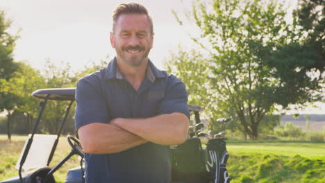 Portrait-Of-Smiling-Mature-Male-Golfer-Standing-By-Buggy-On-Golf-Course