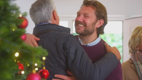 Paar-Begrüßt-ältere-Eltern,-Die-Mit-Geschenken-Zur-Weihnachtsfeier-Ankommen